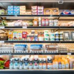 chef analyzing stainless double-door fridge from a widespread restaurant supply shop